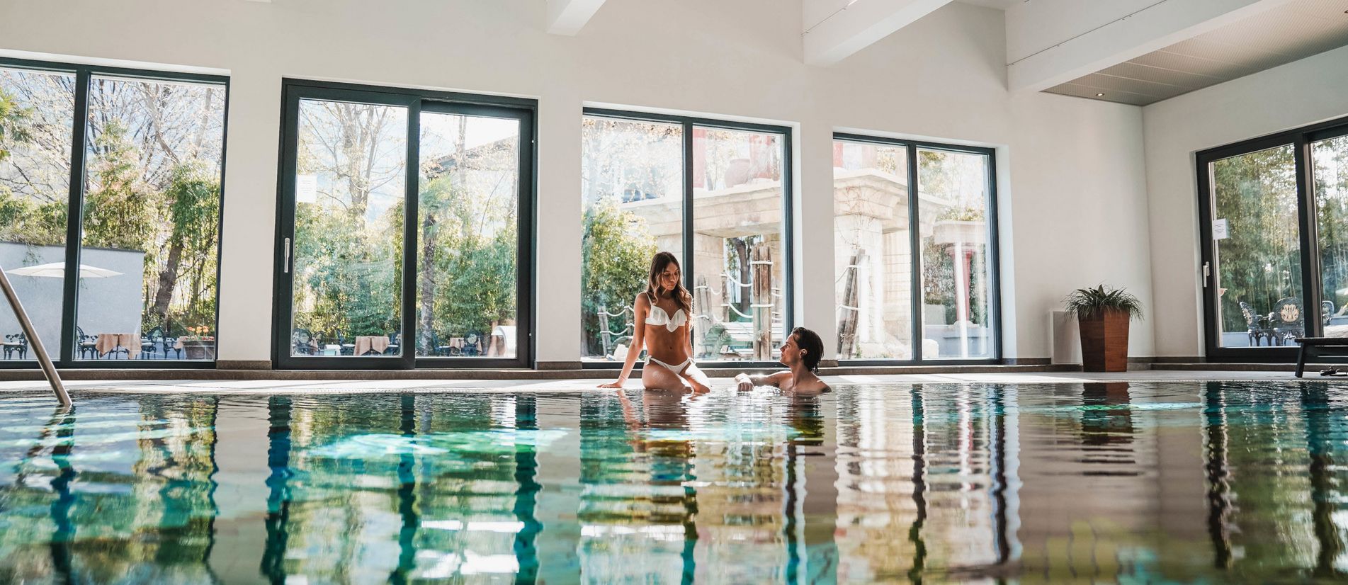 Hallenbad im Hotel Vier Jahreszeiten in Südtirol mit Panoramafenstern und Liegestühlen Hallenbad im Hotel Vier Jahreszeiten in Südtirol mit Panoramafenstern und Liegestühlen